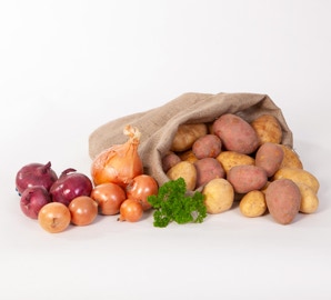 Gelbe und rote Kartoffeln in Jutebeutel mit hellen und roten Zwiebeln