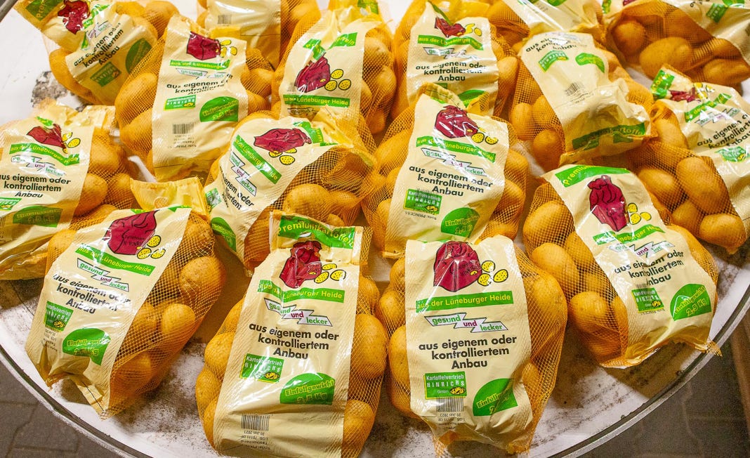 Mehrere Beutel mit kleinen Kartoffeln auf einem Tisch.